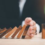 Human hands blocking wooden sticks